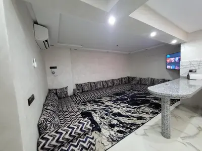 a living room with a couch and a table at Duplex+2 salles de bain à 5 min de l'aéroport in Marrakech