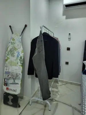 a rack with clothes and a surfboard in a room at Duplex+2 salles de bain à 5 min de l'aéroport in Marrakech