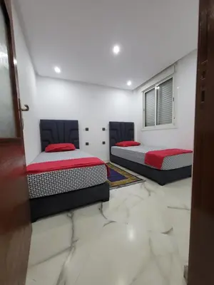 two beds in a room with marble floors at Duplex+2 salles de bain à 5 min de l'aéroport in Marrakech