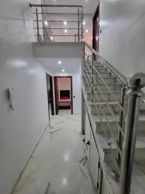 a staircase in a room with white walls and marble floors at Duplex+2 salles de bain à 5 min de l'aéroport in Marrakech