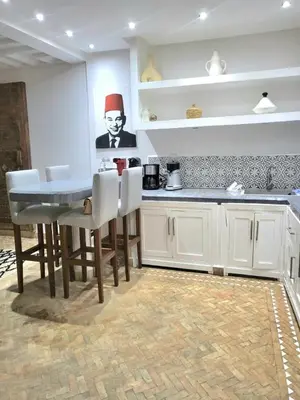 a kitchen with a table with a chef on the wall at Riad Melilo avec piscine chauffée in Marrakech