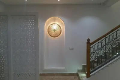 a hallway with a staircase with a light on the wall at Riad Melilo avec piscine chauffée in Marrakech