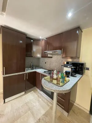 a kitchen with wooden cabinets and a granite counter top at Apartment Gueliz in the best location in Marrakesh in Marrakech