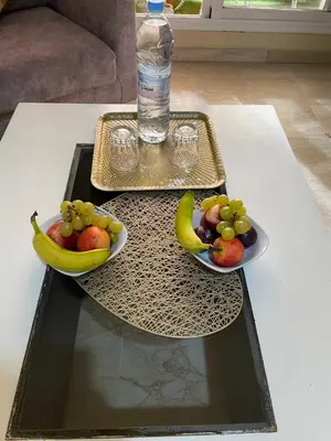 a table with two plates of fruit and a bottle of water at Apartment Gueliz in the best location in Marrakesh in Marrakech