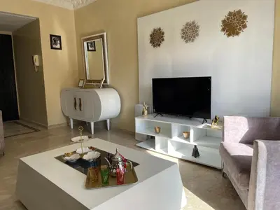 a living room with a tv and a couch and a table at Apartment Gueliz in the best location in Marrakesh in Marrakech