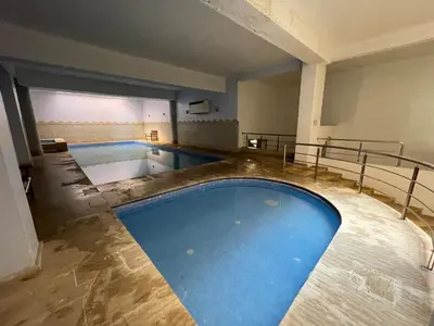 a large swimming pool with blue water in a building at Apartment Gueliz in the best location in Marrakesh in Marrakech