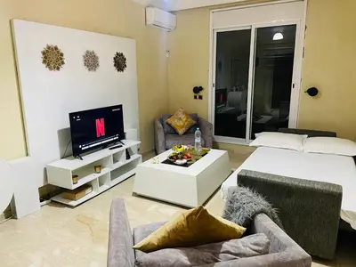 a living room with a bed and a tv at Apartment Gueliz in the best location in Marrakesh in Marrakech