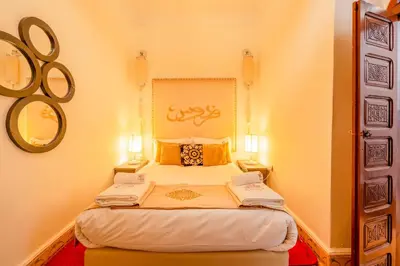 a small bedroom with a bed with two lamps at Riad médina- 3 Rooms Marrakech in Marrakech