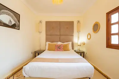 a bedroom with a large white bed and a window at Riad médina- 3 Rooms Marrakech in Marrakech