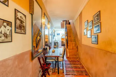 a hallway with a table and pictures on the wall at Riad médina- 3 Rooms Marrakech in Marrakech