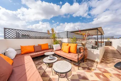a patio with a couch and a table on a balcony at Riad médina- 3 Rooms Marrakech in Marrakech