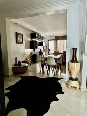 a large living room with a table and a vase at Appartment Jnane Atlas in Marrakech