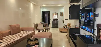 a living room with a couch and a dining room at Appartment Jnane Atlas in Marrakech