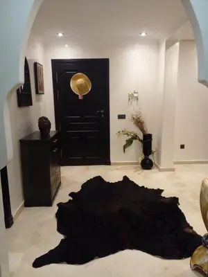 a living room with a black door and a black rug at Appartment Jnane Atlas in Marrakech