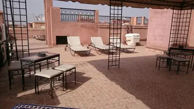 a patio with chairs and tables and chairs at Appartment Jnane Atlas in Marrakech