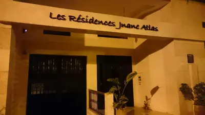 a building with a sign that reads los retailers junior aids at Appartment Jnane Atlas in Marrakech
