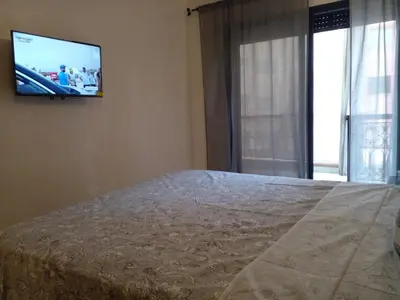 a bedroom with a bed and a television on the wall at Appartment Jnane Atlas in Marrakech