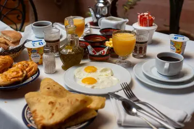 a breakfast table with eggs and bread and coffee at Riad N 15 Zefriti in Marrakech