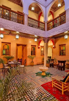 a large room with tables and chairs and a fountain at Riad N 15 Zefriti in Marrakech