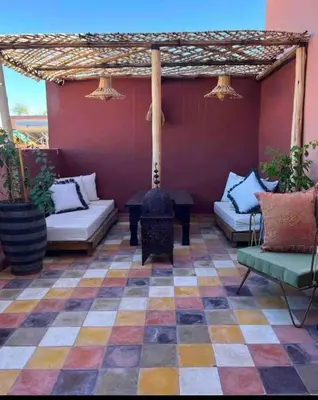 an outdoor patio with a fireplace and couches at Dar Mawa, a 1 min de Jemaa el Fna in Marrakech