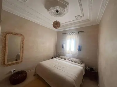 a bedroom with a white bed and a mirror at Dar Mawa, a 1 min de Jemaa el Fna in Marrakech