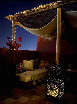 a room with a bed under a canopy with lights at Dar Mawa, a 1 min de Jemaa el Fna in Marrakech