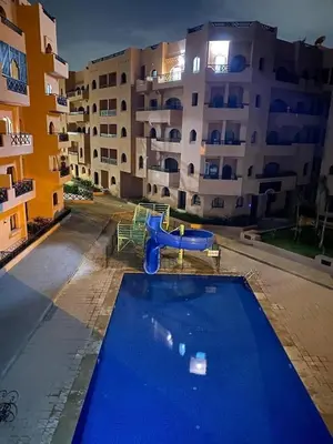 a swimming pool with a slide in front of a building at premium village 106 in Marrakech