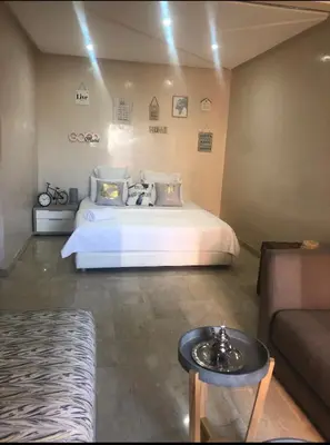 a bedroom with a white bed and a couch at Studio au centre in Marrakech