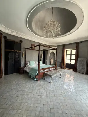 a large bedroom with a bed and a chandelier at Villa Jude in Marrakech