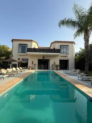 a house with a swimming pool in front of a house at Villa Jude in Marrakech