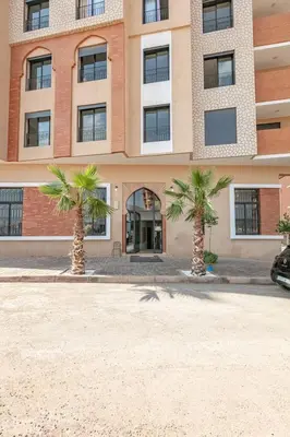 two palm trees in front of a building at Brand New! Charming and Comfortable Flat in Gueliz in Marrakech