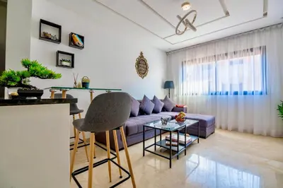 a living room with a purple couch and a table at Deluxe KING Bed SUITE W/POOL in Marrakech