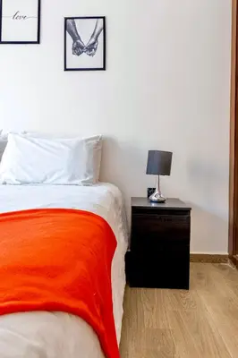 a bedroom with a bed with an orange blanket and a lamp at Deluxe KING Bed SUITE W/POOL in Marrakech