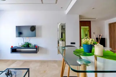 a dining room with a glass table and a tv at Deluxe KING Bed SUITE W/POOL in Marrakech