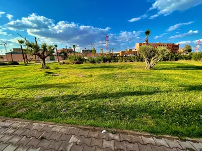 a field of grass with trees and buildings in the background at Deluxe KING Bed SUITE W/POOL in Marrakech