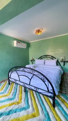 a bed in a room with a green wall at RIAD GJULJA in Marrakech