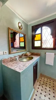 a bathroom with a sink and stained glass windows at RIAD GJULJA in Marrakech