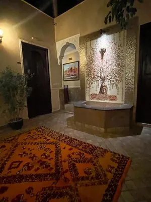 a room with a rug on the floor and a large room with a rug at RIAD GJULJA in Marrakech