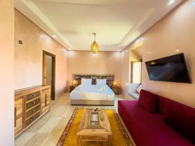 a large bedroom with a bed and a couch at Riad Tonaroz in Marrakech