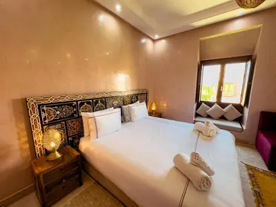 a bedroom with a large bed with towels on it at Riad Tonaroz in Marrakech