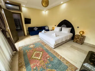 a bedroom with a white bed and a blue couch at Riad Tonaroz in Marrakech