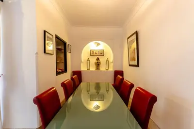 a dining room with a green table and red chairs at Riad Rouge Gorge in Marrakech