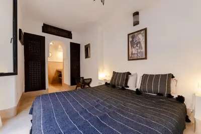 a bedroom with a large bed with a blue blanket at Riad Rouge Gorge in Marrakech