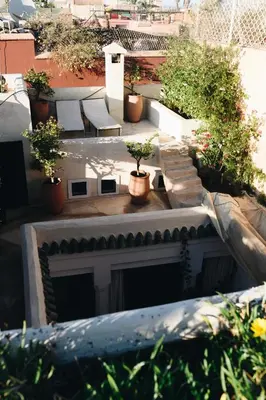 a patio with benches and potted plants on a building at Riad Rouge Gorge in Marrakech