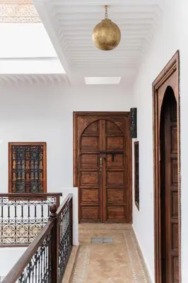 a hallway with a wooden door and stairs at Riad of the Moon in Marrakech