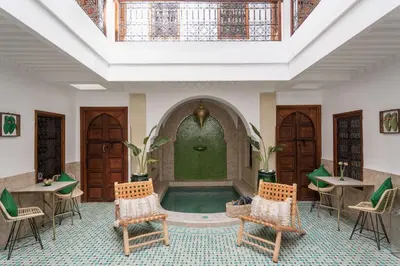 a pool in a room with chairs and a fountain at Riad of the Moon in Marrakech