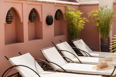 a row of white chairs and tables on a patio at Riad of the Moon in Marrakech