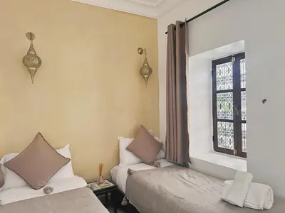 a bedroom with two beds and a window at Riad of the Moon in Marrakech