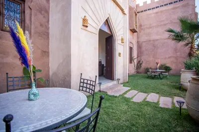 a patio with a table with a vase on it at Riad Azia in Marrakech