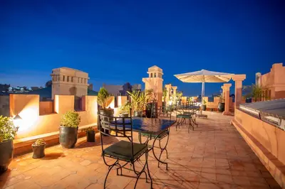 a patio with a table and chairs and an umbrella at Riad Azia in Marrakech
